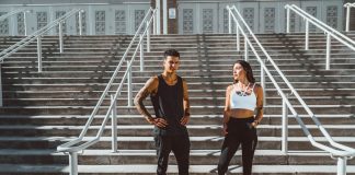 Gym Clothes: is it Worth Bothering a man and a woman in sportswear are standing on the stairs