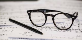 Where Can You Listen to the Music of Modern Famous Composers Live? glasses and pen on the music notes paper