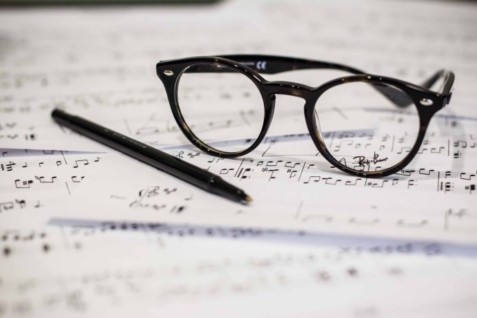 glasses and pen on the music notes paper