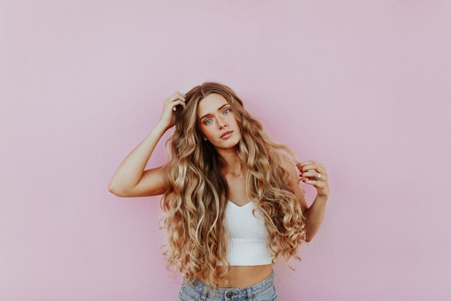 woman-standing-next-to-pink-wall-while-scratching-her-head