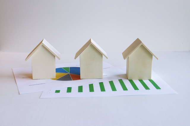 three-small-houses-sitting-on-top-of-a-piece-of-paper