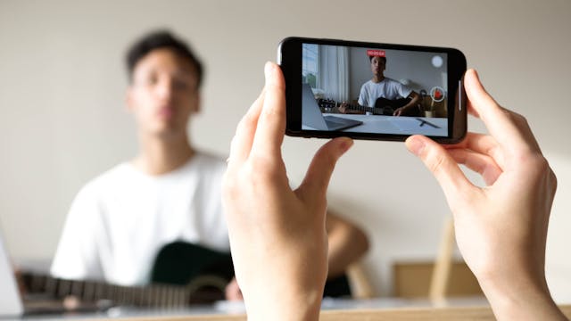 person-recording-a-man-playing-guitar